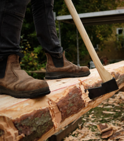 Person der hugger råt tømmer med økse
